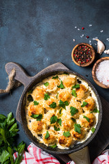 Meatballs in cream sauce on dark stone table top view.