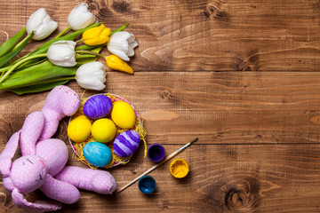 Easter eggs and tulips on wooden planks, bunny