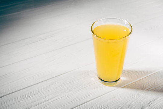Candid image of one glass full of yellow juice