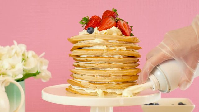 Shrove Pancake Tuesday, last day before Lent, stack of pancakes cake prepared with layers of whipped cream and fresh berries.