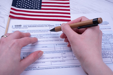 Filing form 1040 US Individual Income Tax Refund next to Flag of USA.