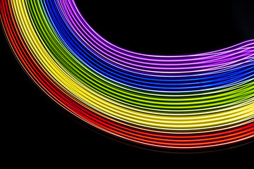 Abstract lines made with light painting with the colors of the rainbow on black background