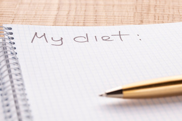 Top view workplace notebook and pen on wood table background, retro effect. Inscription - My diet.