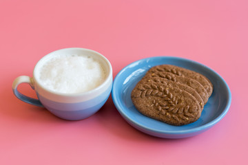 cup of cappuccino, cookies with chocolate. coffee cup with cookie for breakfast morning. On a pink...