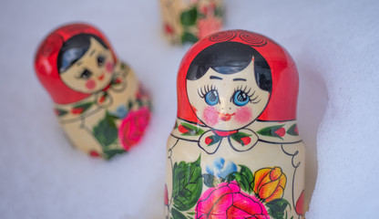 Traditional russian wooden nesting dolls Matryoshka arranged in the real glittering snow.