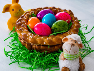 Ein selbst gebackenes und geformtes Osternest aus Hefeteig mit bunten Ostereiern