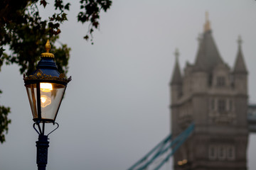 Fototapeta na wymiar Street lantern against the Tower bridge in deep morning fog. London, the UK