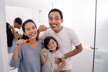 happy asian family brush their teeth together
