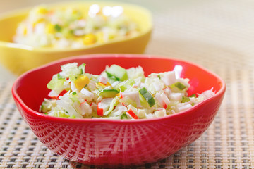 Salad with cucumbers and crabs in colored ceramic plates. 