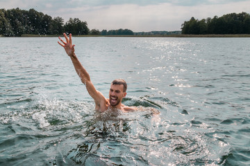 Drowning man. Sticking hand out of water.