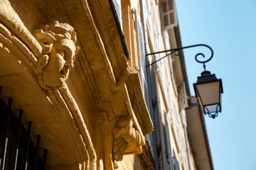 A yellow stone cherub sitting above a doorway in beautiful Aix-en-Provence, France