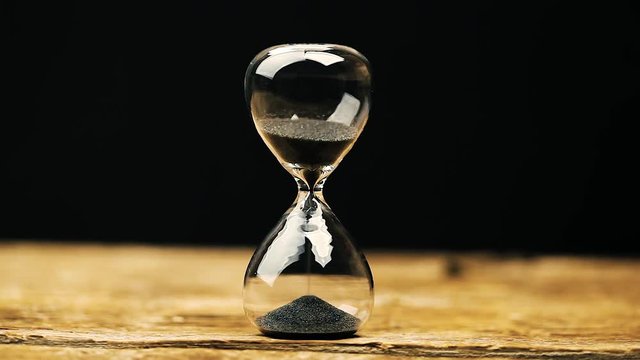 Sand running through the bulbs of an hourglass.