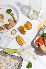 After banquet is finished. Wasted food on table after dinner party. Leftovers, empty plates, left half eaten food and meals. Top view