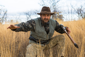 Hunter with a hat and a gun in search of prey in the steppe	