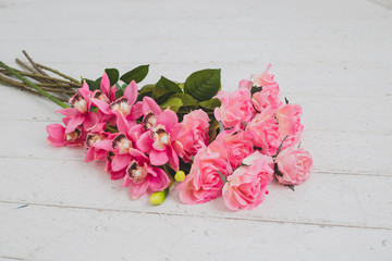 Pink flowers on white wooden background