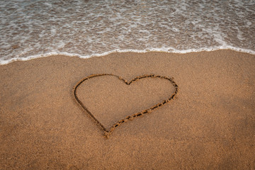 Valentine’s day concept. Heart drawn on the shore Couple celebrating valentine’s day near the sea at the beach. Icon of love Love is beautiful and forever. Lovely holiday landscape exotic postcard