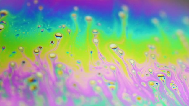 Psychedelic background of motion surface of colorful soap bubble