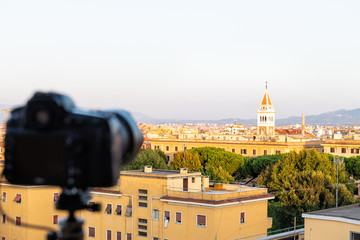 Italian town of Rome, Italy cityscape skyline with high angle view of architecture old buildings during sunset with defocused generic camera on tripod