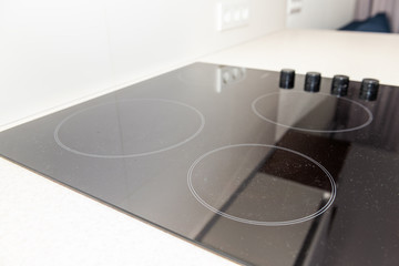 Macro closeup of modern luxury electric cook stove top stovetop cooktop with glass reflection and...