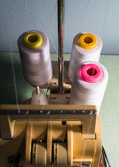spools of thread and needles on wooden background