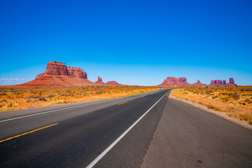 Endless infinite road that goes through the Monument Valley National park with amazing rock...