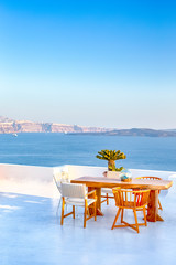 Romantic Tranquil Open Air Cosy Terrace Restaurant in Beautiful Oia Village on Santorini Island in Greece Before the Sunset.