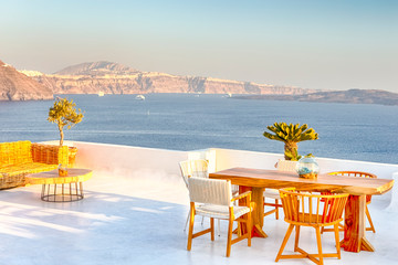 Romantic Tranquil Open Air Cosy Terrace Restaurant in Beautiful Oia Village on Santorini Island in Greece Before the Sunset.