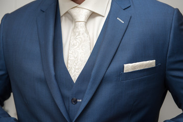 Grooms morning preperation closeup, blue suit