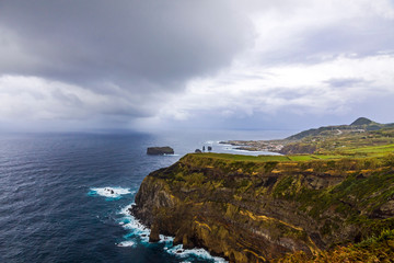 Atlantic Ocean coast of Sao Miguel Island, the largest island in the Portuguese archipelago of the Azores. Feteiras village on background