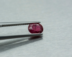 Precious ruby stone carved and fastened with tweezers