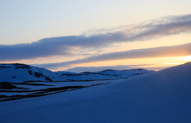 Winter time, snow shore, Russia, landscape of beautiful wild nature of north sees. Beautiful snow winter ice and cold landscape, picturesque view with mountains on horizon, sky clouds, sun lens flare