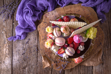 Luxurious Purple cake decorated with a bise, marshmallow, berries and fresh flowers.  Wedding sv. valentine cake