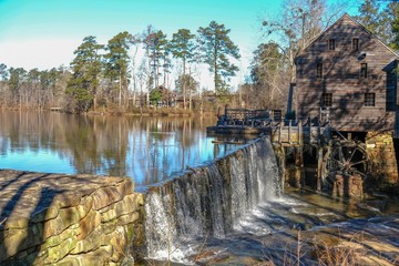 Scenic winter view of the waterfall and dam by the old gristmill at Historic Yates Mill County Park in Raleigh North Carolina.