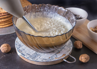 Whipping cream and eggs for homemade cake with electric whisk