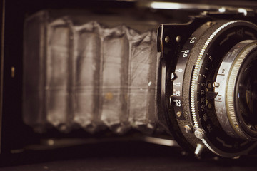 Bellows analogue camera on the black background and vintage or retro concept
