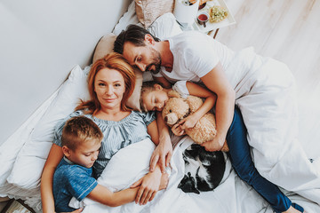 Happy loving family sleeping together in bed