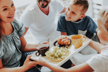 Children bringing breakfast to parents in bed