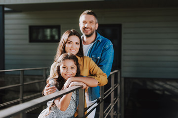 Smiling couple with daughter are locating outdoor
