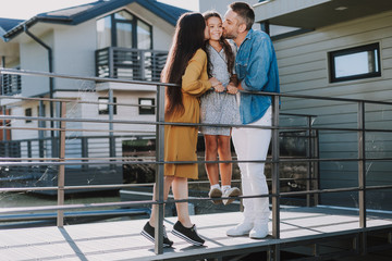Happy family is standing on small bridge