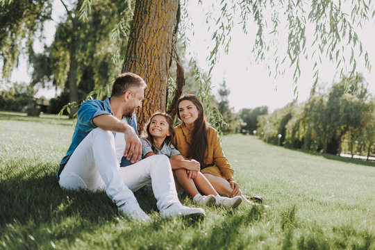 Smiling family is having rest on grass