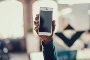 Modern smartphone in the hand of Afro-American person