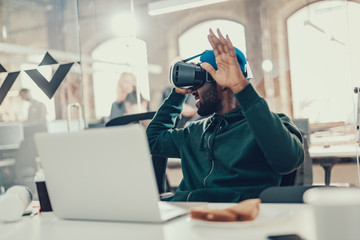 Man in virtual reality glasses turning his head and smiling