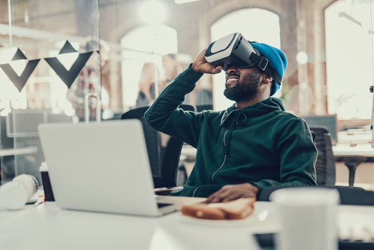 Positive Afro-American man putting head up and exploring virtual reality