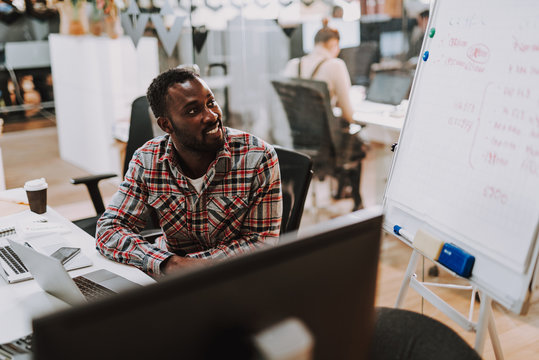 Enthusiastic office worker smiling and looking at whiteboard