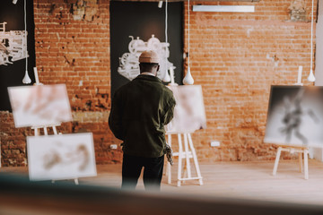 Rare view of the man looking at pictures in the gallery
