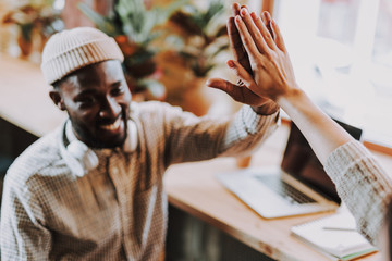 Selective focus of happy man giving five to his friend and smiling