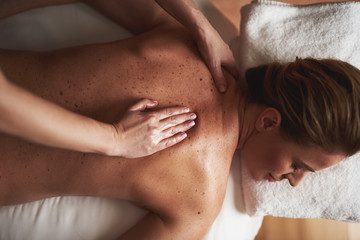 Top view of young lady having massage in spa salon