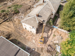 aerial top view of urban demolition site with working heavy machinery