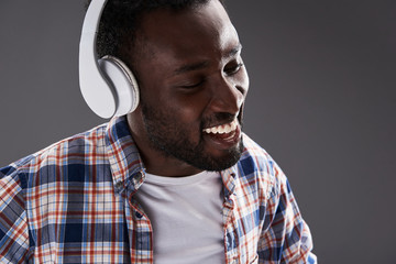 Close up of a smiling afro american man using headphones