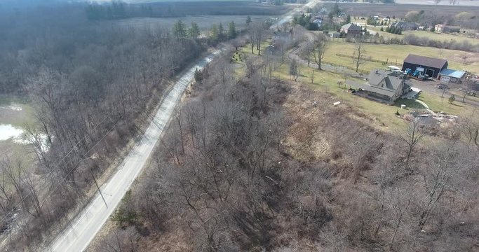 Flying Along Road On Hill Near Ranch House And Farmland Aerial View